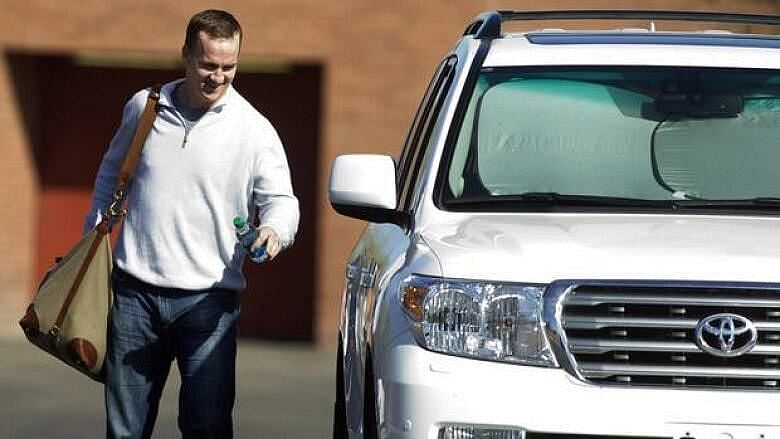 Peyton Manning with his white toyota land cruiser suv