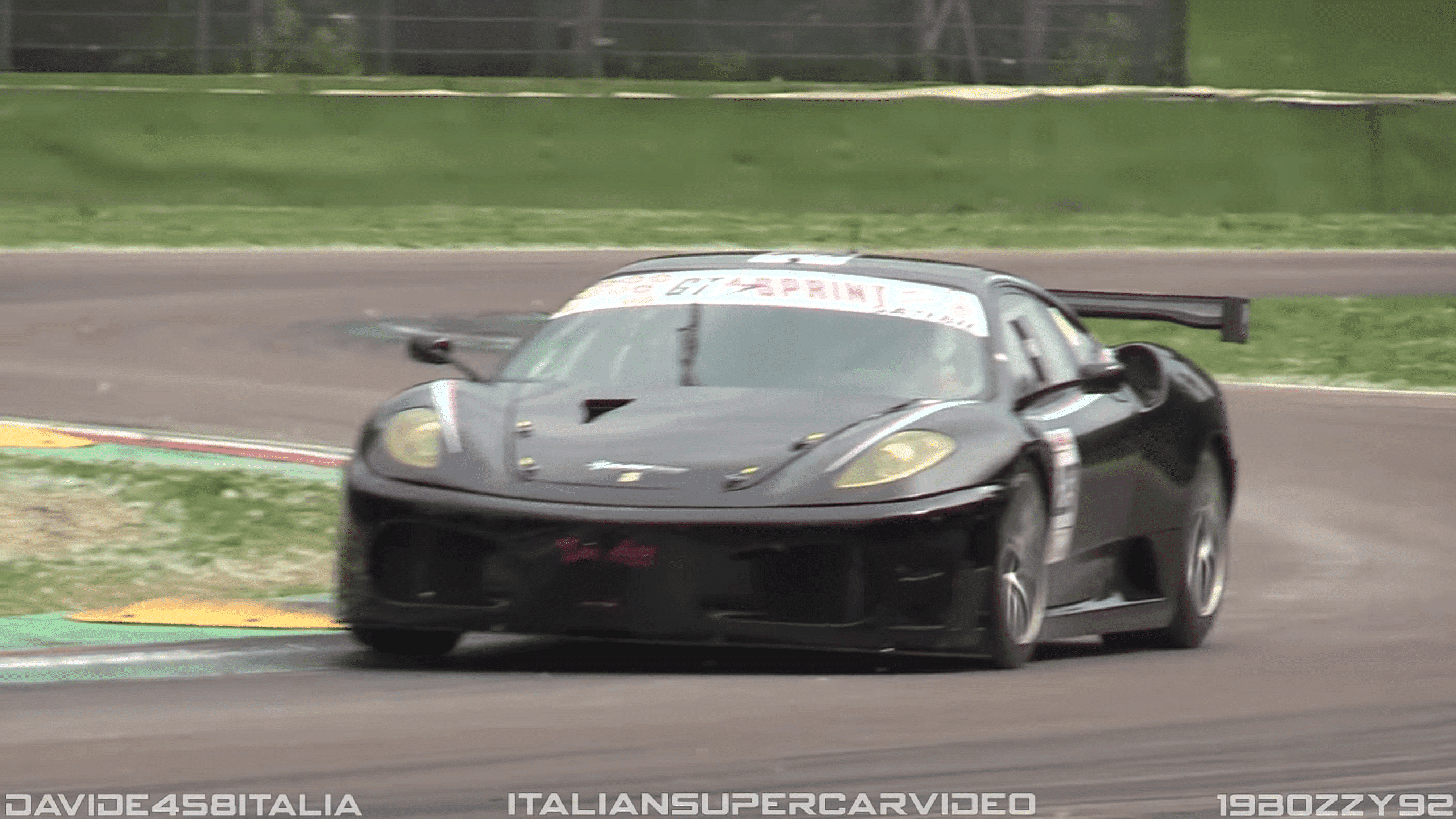 Black Ferrari F430 GT2 racing around a circuit