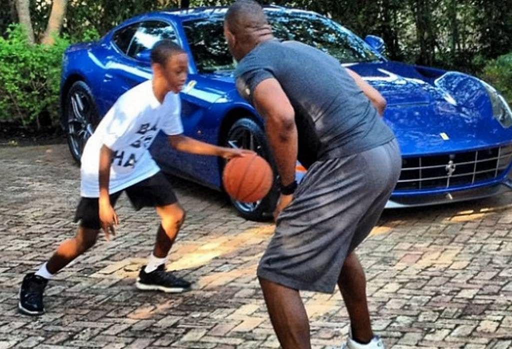 Dwayne Wade playing with his son in front of his Blue Ferrari F12 Berlinetta